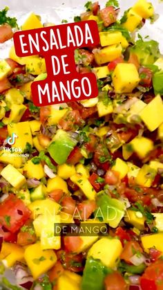 a salad with mangoes, tomatoes and other vegetables on it is shown in spanish