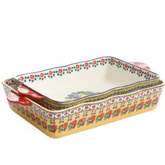 two rectangular dishes with red handles and floral designs on the bottom, one is holding a spoon