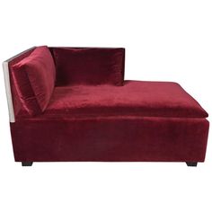 a red velvet chaise lounge chair with two pillows on the back and one arm