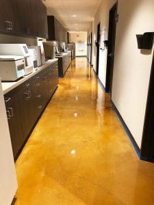 a long hallway with cabinets and microwaves on each side, in an office building