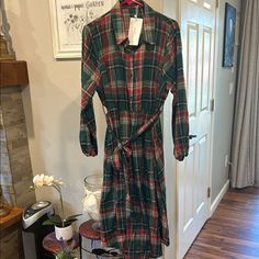 This Dress Features A Shirt-Style Collar, Long Cuffed Sleeves, And A Tie Belt At The Waist. Made Of A Soft Flannel-Like Material, It Is Perfect For Casual Or Work Occasions. Casual Plaid Holiday Dress, Dress With Collar, Green And Red, Soft Flannel, Collar Dress, Tie Belt, Cuff Sleeves, Red Plaid, Dark Green