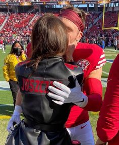 two football players hug each other on the field