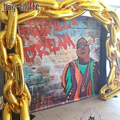 a large gold chain frame in front of a wall with an image of a man on it