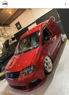 a red car parked in a garage next to other cars