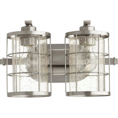 two lights that are on the side of a metal wall mounted fixture with clear glass coverings