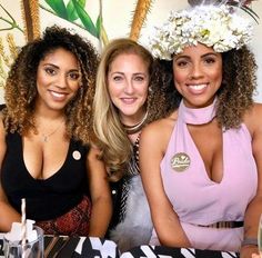 three beautiful women sitting next to each other at a table