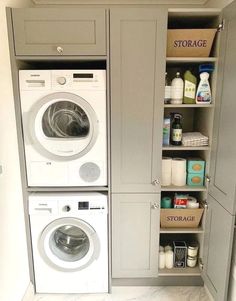 a washer and dryer in a small laundry room with gray cupboards on the wall