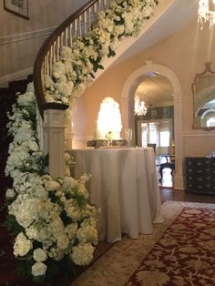 a staircase with flowers on it and a table in the middle is set up for a formal function