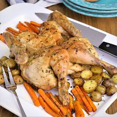 a white plate topped with chicken, potatoes and carrots