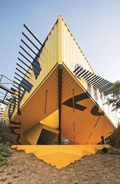 an unusual yellow building with stairs leading up to it