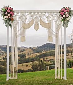 an outdoor wedding ceremony setup with flowers and macramotes on the arborette