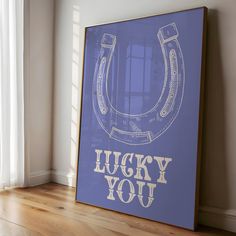 a blue poster with the words lucky you on it in front of a wooden floor