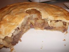 a piece of meat and cheese pie on a white plate with a bite taken out