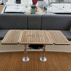 a wooden table sitting on top of a boat's deck next to a couch