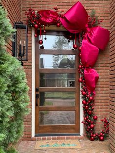 Front door Christmas bow decor red christmas door #christmasdecordiy Christmas Door Covering, Christmas Bow Door Decor, Over Door Christmas Decorations, Christmas Decor Arch, Bow Door Christmas, Christmas Front Door Bow, Christmas Door Ribbon, Bow On Door Christmas, Winter Front Porch Ideas After Christmas