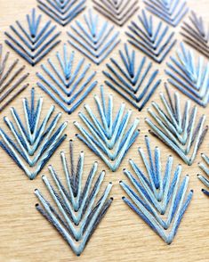 several different types of blue and silver metal shapes on a wooden surface with one being cut out