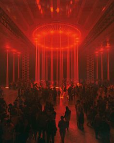 a large group of people standing around in a room with red lights on the ceiling