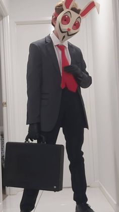 a man in a suit and tie with a mask on his head holding a briefcase