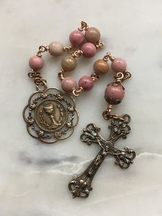 Beautiful First Communion pocket rosary. 6 and 8mm Rhodonite Gemstones 20 gauge solid bronze wire Bronze Medals Antique Jewelry With 8mm Beads For Gift, Antique Jewelry With 8mm Beads As Gift, Antique 8mm Beads Jewelry As Gift, Antique 8mm Beads For Jewelry Making, Spiritual Rose Gold Jewelry With 8mm Beads, Spiritual Rose Gold 8mm Beaded Jewelry, Bronze Rosary With Round Beads As Gift, Bronze Rosary As Gift, Pocket Rosary