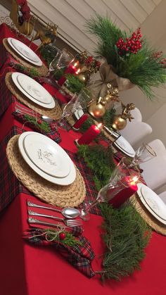 a table set for christmas dinner with place settings