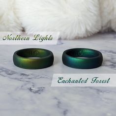 two rings sitting next to each other on top of a marble table with the words northern lights enchanted forest