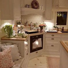 a kitchen filled with lots of white cabinets and counter top space next to an oven