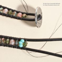 two pieces of leather with beads on them sitting next to each other in front of a button