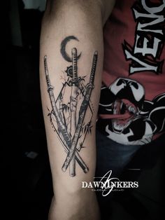 a man's arm with two crossed swords on it