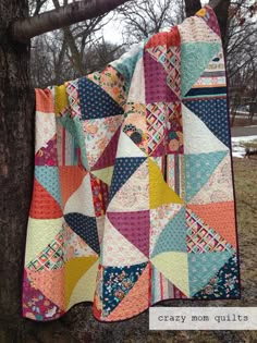 a quilt hanging from a tree in the snow