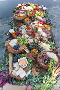 a long table filled with lots of different types of cheeses and fruit on top of it