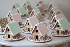 a table topped with lots of small houses covered in frosting and icing on top of each other