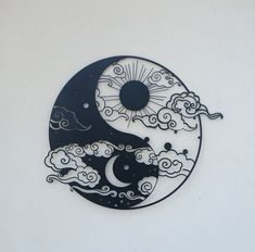 a black and white yin - yang design on the side of a building with clouds in the sky