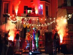 a group of people standing in front of a building with clowns on the balcony