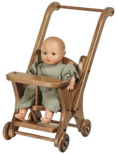 a baby doll sitting in a wooden stroller