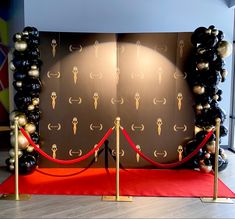 a red carpet with black and gold balloons on it