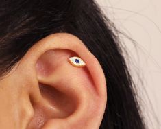 a close up of a person's ear with an evil looking eye on it