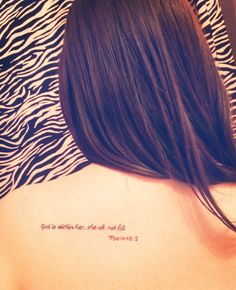 the back of a woman's shoulder with a tattoo saying, that is written in cursive writing