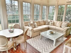 a living room filled with furniture and windows