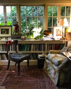 a room filled with lots of books on top of a table next to a window