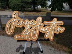 a wooden sign that says jenny and dustin on it in front of a park with trees