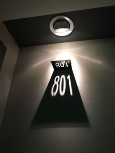 an illuminated sign in the corner of a room with lights on and below it that reads 108