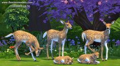 several deer are standing in the grass near some trees and flowers, while two young ones sit on the ground next to them