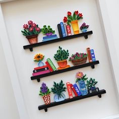 three black shelves filled with different types of plants and books on top of each shelf