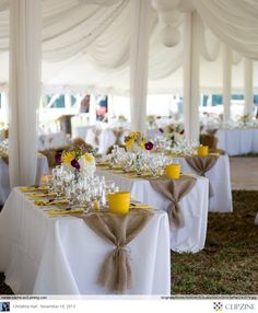 the tables are set up with yellow and white centerpieces, napkins, and cups