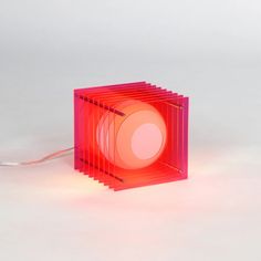 a red light that is sitting in the middle of a room with wires attached to it