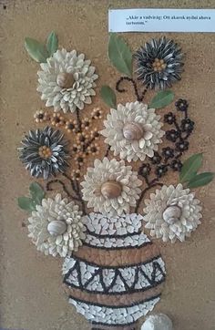 a painting of flowers in a vase on the wall next to shells and seashells