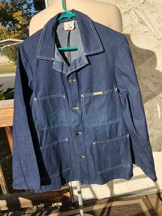 "Vintage 80's SBG Blue Denim Chore Jacket 100% Cotton Made in Canada New never worn Button up 4 pockets on front of jacket Field style/ working/ utility Size 40 Measurements taken while laying flat Neck 6\" Pit to Pit 20\" Sleeves from pit tot edge19\" Length from shoulder to bottom 29\" Purchase price includes free shipping in Canada and the USA International shipping is available, please contact before purchase for shipping quote Any questions, just  ask! Vintage item, regular wear due to age should be expected Any known flaws/ markings will be listed No returns / exchanges, but please contact if there is an issue with your item" Vintage Blue Button-up Utility Jacket, Retro Button-up Utility Jacket With Pockets, Vintage Denim Blue Utility Jacket With Pockets, Vintage Denim Blue Utility Jacket For Fall, Retro Button-up Denim Jacket For Work, Vintage Blue Utility Jacket With Pockets, Vintage Blue Utility Jacket For Streetwear, Retro Medium Wash Button-up Outerwear, Vintage Medium Wash Cotton Utility Jacket