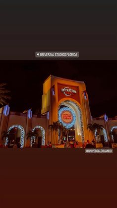 the universal studios building is lit up at night