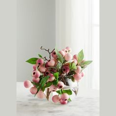 a vase filled with lots of pink flowers on top of a white table next to a window