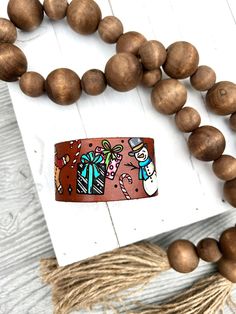 a wooden beaded necklace with an image of a cat on it and some beads